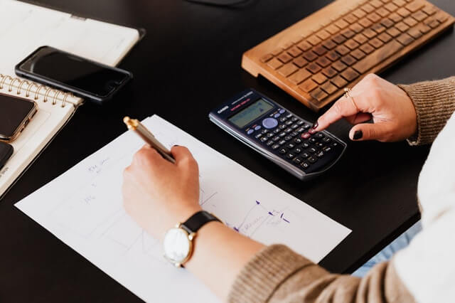 Crop Woman Using Calculator And Taking Notes On Paper 1